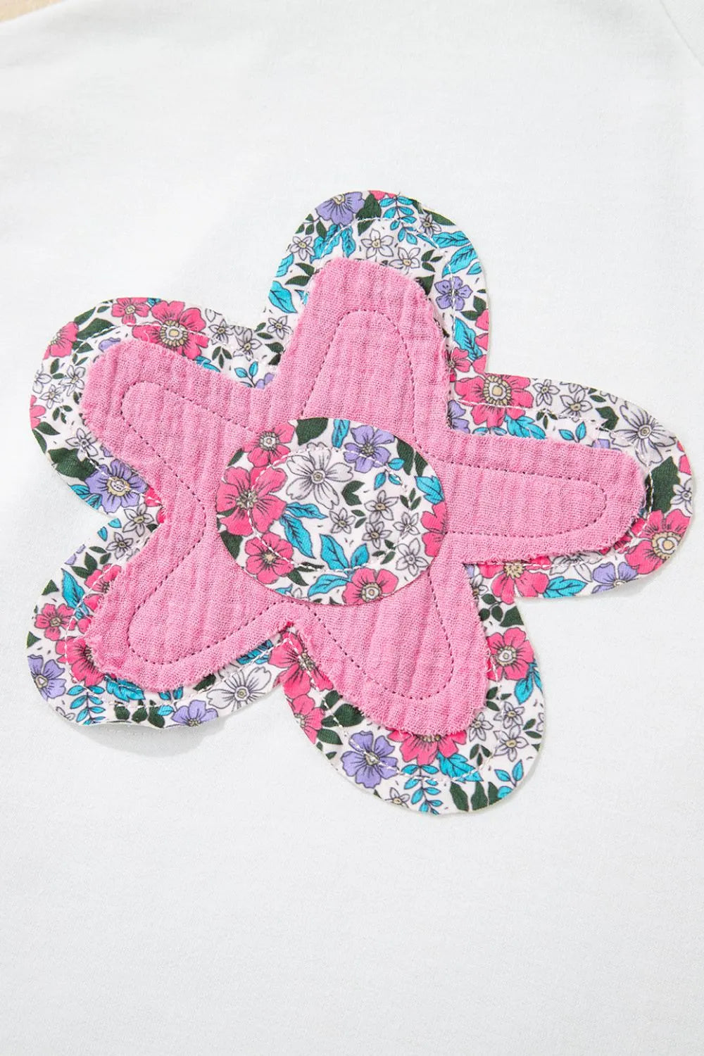 Blusa floral con mangas dolman con un diseño colorido en forma de flor en la parte frontal