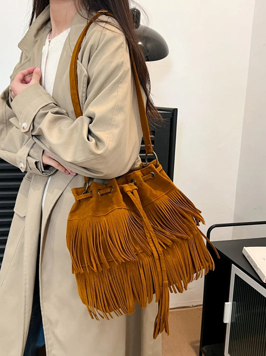 Mujer con bolso de hombro elegante de gamuza amarilla con flecos detallados y diseño moderno